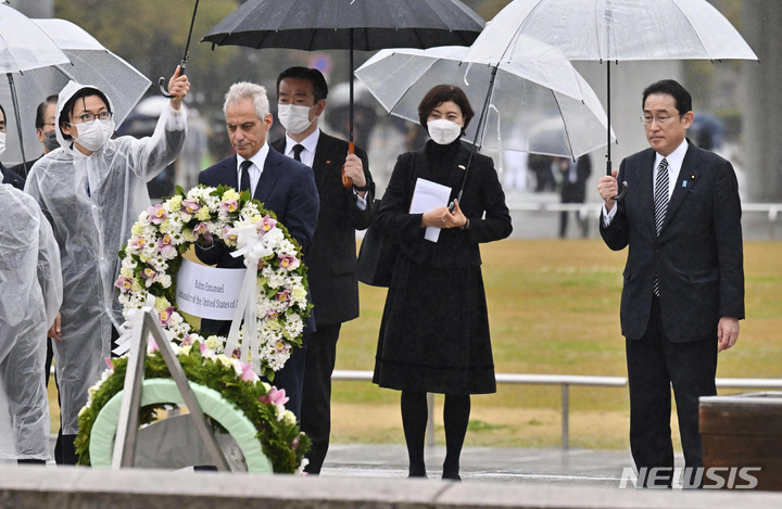 [히로시마=AP/뉴시스]지난3월26일 일본 히로시마의 평화기념공원에 마련된 원폭 희생자 위령비에 람 이매뉴얼 주일 미국대사(가운데)가 헌화하고 있다. 그는 기시다 후미오 일본 총리(가장 오른쪽)와 함께 히로시마를 방문했다. 2022.05.23.