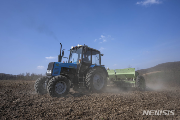 [후사키우(우크라이나)=AP/뉴시스]우크라이나 서부 후사키우의 농경지에서 26일 농부가 밀을 경작하고 있다.  2022.3.29…