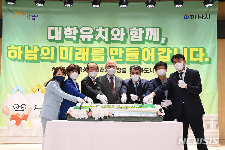 김상호 하남시장(오른쪽)이 31일 하남시대학유치위원회 출범식에서 위원들과 축하떡을 자르고 있다