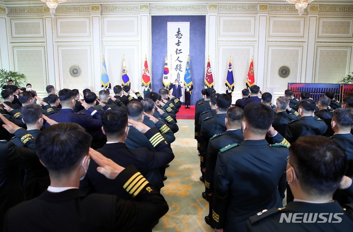 [서울=뉴시스] 김진아 기자 = 문재인 대통령이 31일 오후 청와대 영빈관에서 열린 준장 진급자 삼정검 수여식에서 진급자들의 거수경례에 답하고 있다. 삼정검은 육·해·공 3군이 일체가 돼 호국·통일·번영의 3가지 정신을 달성한다는 의미를 담고 있다. 2022.03.31. bluesoda@newsis.com