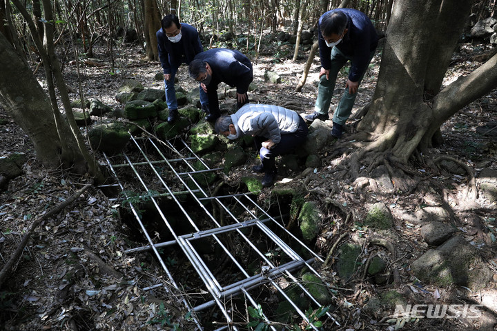 [제주=뉴시스] 백동현 기자 = 지난 29일 오후 제주시 조천읍 동백동산 산책로 옆에서 시민들이 도틀굴을 살펴보고 있다. 도틀굴은 4.3 사건 당시의 피신했던 흔적과 유품들이 발견된 유적 동굴이다. 2022.04.03. livertrent@newsis.com