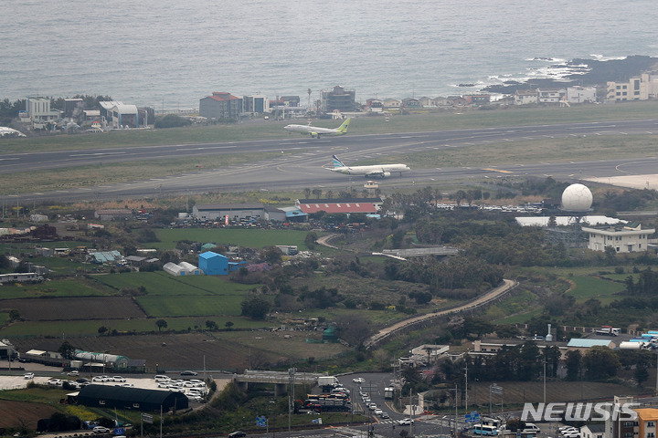 [제주=뉴시스] 백동현 기자 = 지난 31일 오후 제주공항 활주로에 비행기가 이동하고 있다. 현 제주공항 남북활주로 동북 측 지점과 서북 측 지점인 옛 정뜨르 비행장 인근에서는 4.3사건 관련 완전유해 261구와 유해 약 123구가 각각 발견됐다. 2022.04.03. livertrent@newsis.com