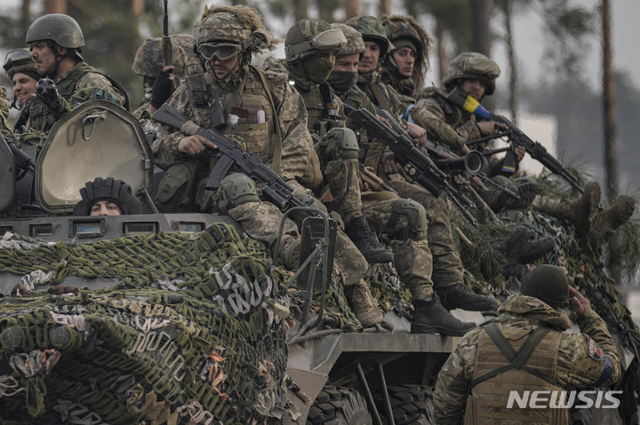 [키이우=AP/뉴시스] 3월31일(현지시간) 우크라이나 키이우 외곽에서 장갑차에 탄 우크라이나 군인들이 러시아군이 밀려난 지역을 통과하며 동료 병사의 경례를 받고 있다. 2022.04.01.