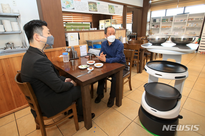 [서귀포=뉴시스] 우장호 기자 = 1일 제주 서귀포 시내 한 음식점에서 KT가 개발한 'AI 서비스로봇'이 음식을 서빙하고 있다. 2022.04.01. woo1223@newsis.com