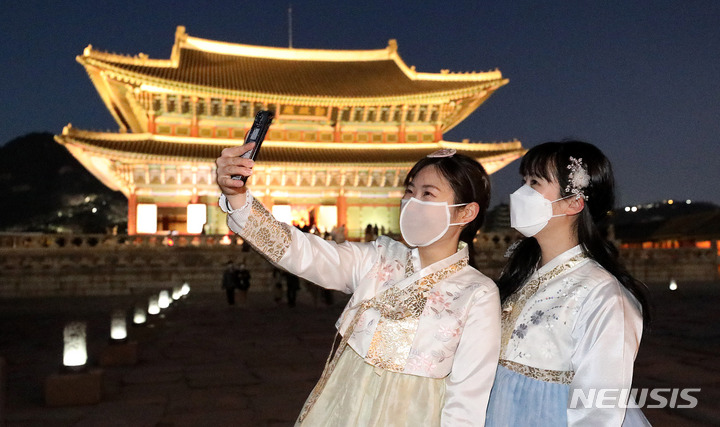 [서울=뉴시스] 추상철 기자 = 경복궁 야간 개장이 시작된 1일 오후 서울 종로구 경복궁에서 한복을 차려 입은 관람객이 기념촬영을 하고 있다. 2022.04.01. scchoo@newsis.com