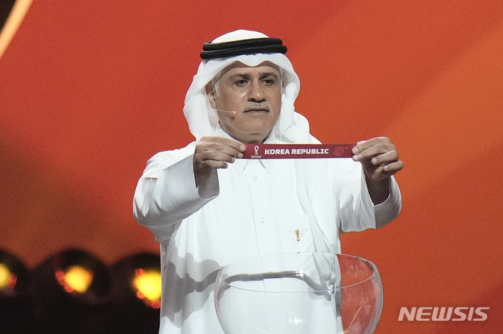[도하=AP/뉴시스] 카타르 축구 전설 아델 아흐메드 말알라가 2일(한국시간) 카타르 도하 전시컨벤션센터(ECC)에서 열린 2022 FIFA 카타르 월드컵 조 추첨에서 한국의 이름이 적힌 종이를 뽑은 뒤 들어보이고 있다. 2022.04.02.