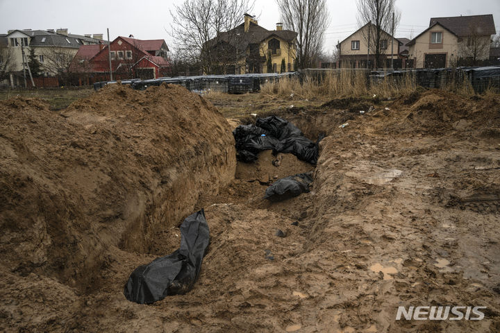[부차=AP/뉴시스] 3일(현지시간) 우크라이나 키이우 인근 부차(Bucha)에서 숨진 사람들의 시신이 집단 매장되고 있다. 우크라이나 당국은 키이우 인근 지역에서 민간인 시신 410구를 수습했다고 밝혔다. 2022.04.04.