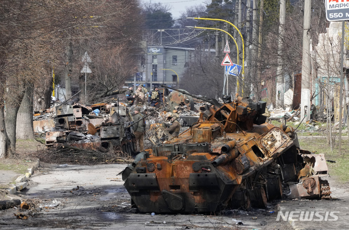 [부차=AP/뉴시스] 4월4일(현지시간) 우크라이나 키이우 외곽 부차 마을에서 우크라이나 군인들이 파괴된 러시아 장갑차 등을 살피고 있다. 러시아는 우크라이나에서의 민간인 학살로 보이는 증거가 드러나면서 전격적인 비난에 직면하고 있다. 2022.04.05.