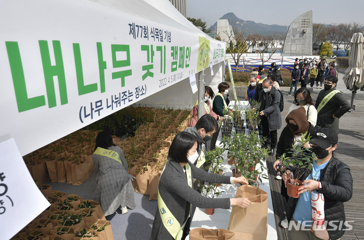 [서울=뉴시스] 정병혁 기자 = 식목일인 5일 오전 서울 종로구 세종로공원에서 열린 '내 나무 갖기 캠페인' 행사에서 시민들이 목수국, 서향(천리향) 등 나무를 받아가고 있다. (공동취재사진) 2022.04.05. photo@newsis.com