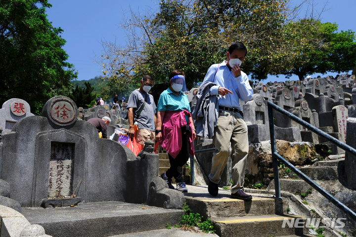 [홍콩=AP/뉴시스] 5일 홍콩에서 마스크를 쓴 한 가족이 청명절을 맞아 성묘차 공동묘지를 찾았다. 2022.04.05