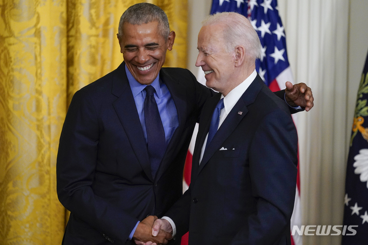 [워싱턴= AP/뉴시스] 5일(현지시간) 백악관 이스트룸에서 재회한 조 바이든대통령과 버락 오바마 전 대통령이 손을 맞잡고 기뻐하고 있다. 
