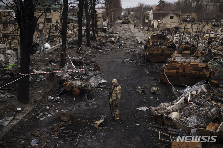 [부차=AP/뉴시스] 6일(현지시간) 우크라이나 키이우 외곽 부차에서 우크라이나 군인이 파괴된 러시아군 전차들을 살피고 있다. 2022.04.07.