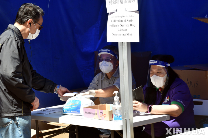 [홍콩=신화/뉴시스] 홍콩 시내에 있는 코로나19 임시 방역센터에서 9일 신속히 감염을 확인할 수 있는 진단키트를 시민에 나눠주고 있다. 2022.04.12