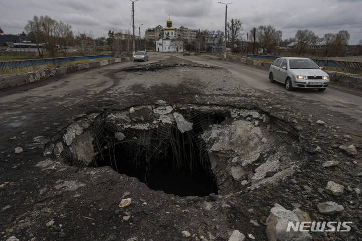 [마카로우=AP/뉴시스] 10일(현지시간) 우크라이나 키이우의 마카로우 마을에서 자동차 한 대가 지난주 러시아군의 공격으로 파괴된 다리 위를 지나고 있다. 2022.04.11.