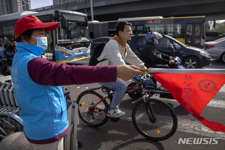 [베이징=AP/뉴시스] 12일 중국 베이징의 한 교차로에서 마스크를 쓴 교통 지도원이 운전자들을 안내하고 있다. 2022.04.12.