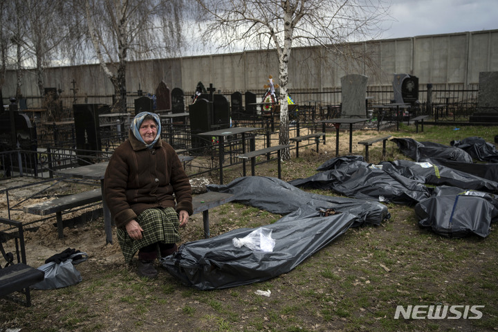 [부차=AP/뉴시스] 12일(현지시간) 우크라이나 부차에서 나디야 할머니(70)가 러시아군에 살해된 아들 바딤(40)의 시신 옆에 허망하게 앉아 있다. 2022.04.13.