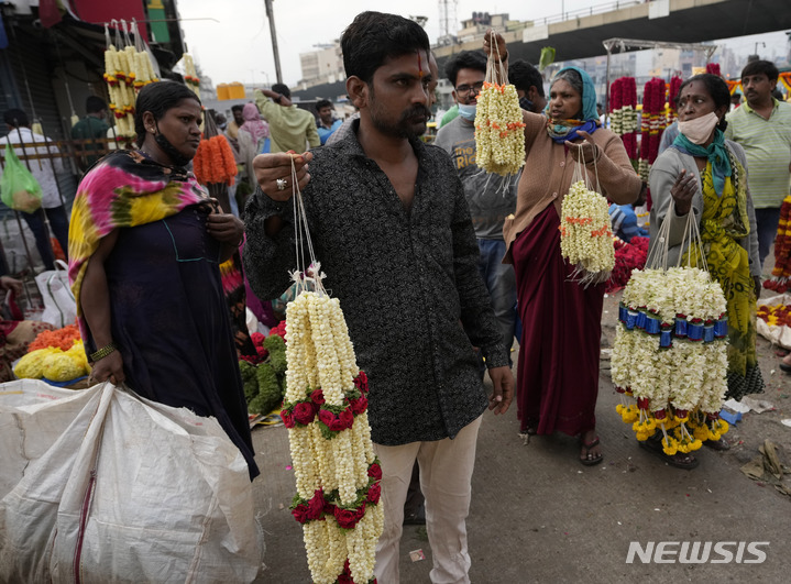 [벵갈루루=AP/뉴시스] 13일(현지시간) 인도 벵갈루루 도매시장에서 마스크를 쓰지 않은 상인들이 꽃을 팔고 있다. 인도 당국이 공공장소에서 마스크 착용 의무화 등 코로나19 규제를 해제하면서 시민들은 일상으로 돌아가고 있다. 2022.04.13. 