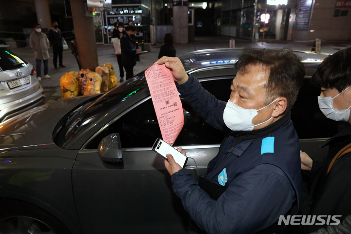 [서울=뉴시스] 김병문 기자 = 경찰청, 서울시, 한국도로공사 관계자들이 14일 오후 서울 강남구 도산대로 일대에서 음주단속 및 과태료 고액·상습 체납, 고속도로 통행료 체납 차량을 단속하고 있다. 관계자가 단속된 자동차세 체납 차량 앞에서 영치증을 들어보이고 있다. 2022.04.14. dadazon@newsis.com