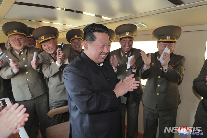 [AP/뉴시스] 북한 정부가 지난달 17일 제공한 날짜 미상의 사진에서 김정은 국무위원장(가운데)이 앞쪽을 바라보며 박수를 치고 웃고 있다. 2022.05.16.