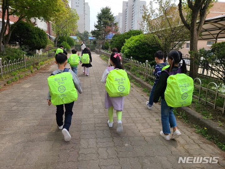 구리지역 초등학생이 가방 안전 덮개를 착용하고 등교를 하고 있다. (사진= 구리시 제공)