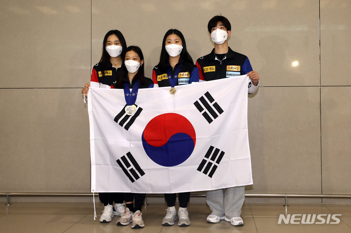 [인천공항=뉴시스] 이영환 기자 =2022 국제빙상경기연맹(ISU) 피겨 세계주니어선수권대회 여자 싱글에서 2006년 김연아 이후로 16년만에 입상한 신지아(왼쪽 두번째)와 선수들이 19일 오후 인천국제공항 제2여객터미널을 통해 귀국해 기념촬영을 하고 있다. 왼쪽부터 위서영, 신지아, 윤아선, 차영현. 2022.04.19. 20hwan@newsis.com