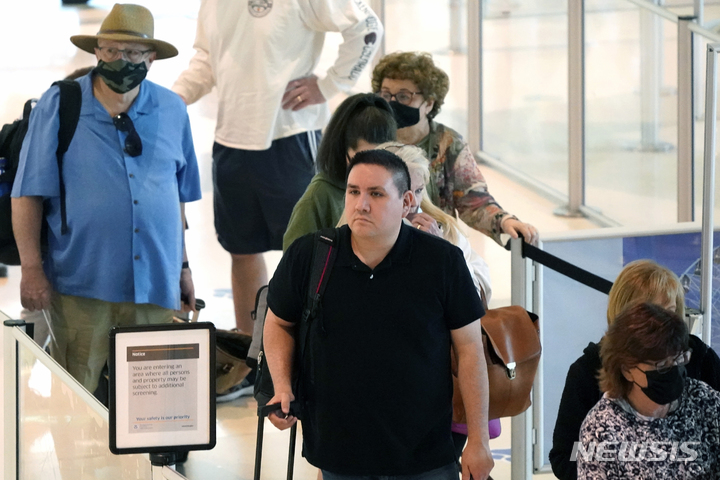 [댈러스=AP/뉴시스] 19일(현지시간) 미국 델러스에 위치한 러브필드 공항 대기 줄에 마스크를 착용한 시민과 착용하지 않은 시민이 섞여 차례를 기다리고 있다. 2022.04.20  