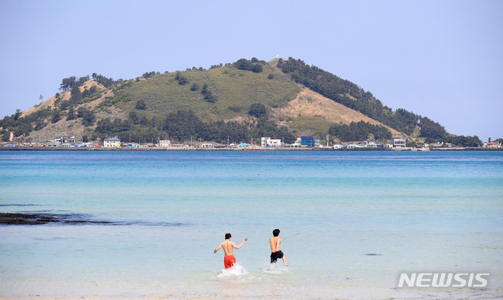 [제주=뉴시스] 우장호 기자 = 맑은 날씨를 보이는 20일 오전 제주시 한림읍 협재해수욕장을 찾은 관광객들이 바닷물에 몸을 담그며 즐거운 시간을 보내고 있다. 2022.04.20. woo1223@newsis.com