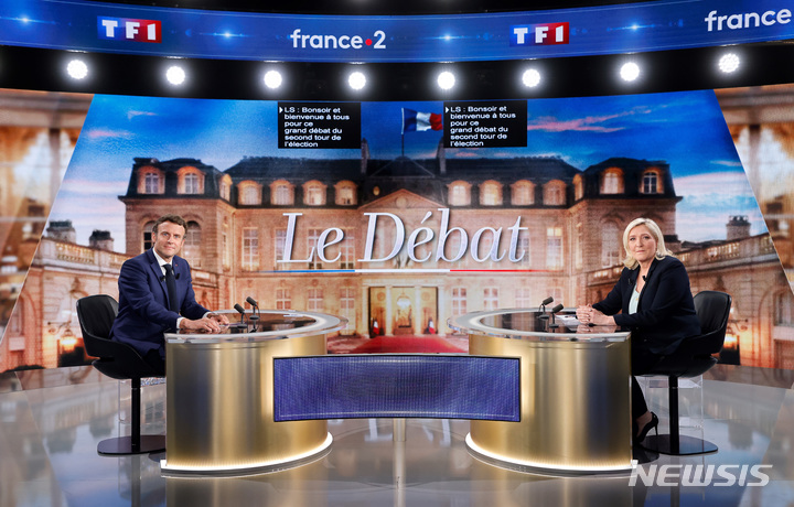 [파리=AP/뉴시스] 재선을 노리는 에마뉘엘 마크롱(왼쪽) 프랑스 대통령과 이에 맞서는 마린 르펜 국민연합 후보가 20일(현지시간) 파리 외곽에서 열린 TV 토론회에 참석해 토론 전 포즈를 취하고 있다. 2022.04.21.