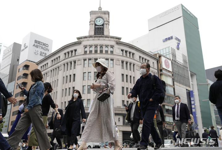 [도쿄=AP/뉴시스] 일본 도쿄 쇼핑가 긴자 거리에서 지난 3월21일 코로나19 예방을 위해 마스크를 착용한 시민들이 횡단보도를 건너고 있다. 2022.12.15.