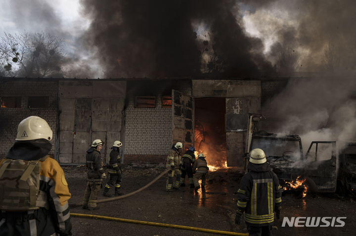 [하르키우=AP/뉴시스] 21일(현지시간) 우크라이나 하르키우에서 소방대원들이 러시아군의 포격으로 발생한 창고 화재를 진압하고 있다. 2022.04.22.