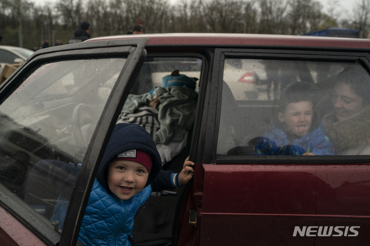 [자포지라=AP/뉴시스] 21일(현지시간) 우크라이나 마리우폴을 탈출한 어린이가 자포지라 난민센터에 도착해 카메라를 향해 미소짓고 있다. 2022.04.22.
