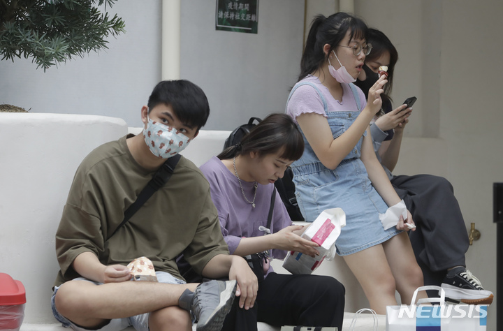 [타이베이=AP/뉴시스] 코로나19가 급속히 퍼지고 있는 대만 수도 타이베이에 있는 상점에서 28일 대기 중인 손님 한 명이 마스크를 벗은 채 아이스크림을 먹고 있다. 2022.04.30