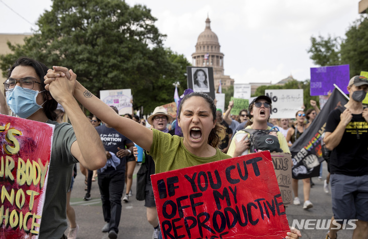 [오스틴=AP/뉴시스] 3일(현지시간) 미 텍사스주 오스틴의 의회 건물 앞에서 손팻말을 든 시위대가 임신중절(낙태) 권리 지지 구호를 외치고 있다. 1973년 임신중절을 합법화한 '로 대 웨이드 판례' 전복에 힘을 실은 연방대법원 의견서 초안이 유출되면서 파문이 일고 있다. '로 대 웨이드' 판결은 임신중절을 헌법이 보장한 사생활의 권리 침해로 규정, 여성의 권리를 인정한 기념비적 판결이다. 2022.05.04.