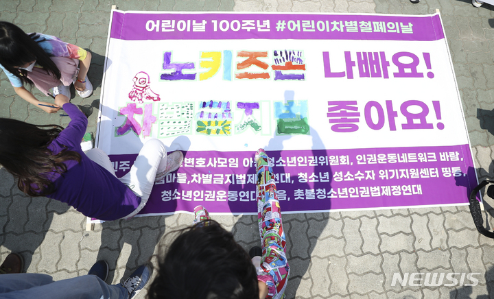 [서울=뉴시스] 최진석 기자 = 어린이들이 지난해 5월4일 서울 영등포 국회 앞에서 열린 '어린이날 100주년, 어린이차별철폐의 날 선포 기자회견'에 참석해 '노키즈존 나빠요!, 차별금지법 좋아요!' 문구에 색칠하는 퍼포먼스를 하고 있다. 2022.05.04. myjs@newsis.com