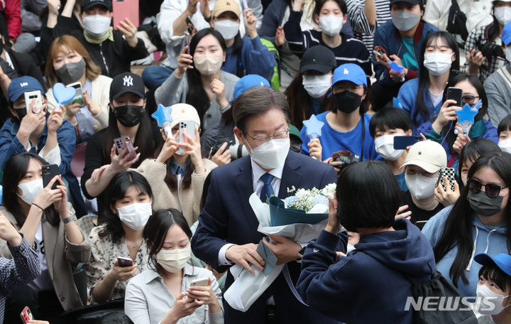 [서울=뉴시스] 전진환 기자 = 이재명 더불어민주당 상임고문이 8일 인천 계양산 야외공연장에서 열린 국회의원 보궐선거(인천 계양을) 출마 기자회견에서 한 지지자로부터 꽃다발을 받고 있다. (공동취재사진) 2022.05.08. photo@newsis.com