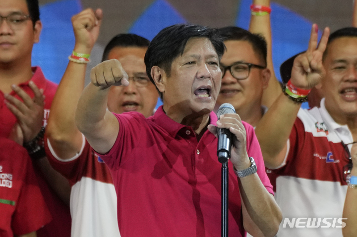 [케손시티=AP/뉴시스]필리핀 케손 시티에서 지난 4월 13일 페르디난드 봉봉 마르코스(64) 전 상원의원이 대선 유세 도중 손을 들어보이고 있다. 2022.05.09.
