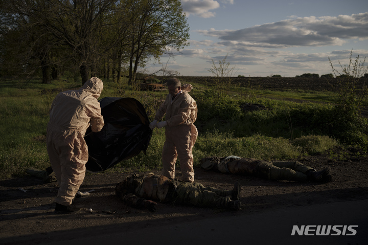 [하르키우=AP/뉴시스] 지난 9일(현지시간) 우크라이나군이 최근 탈환한 하르키우 인근 빌히우카 마을에서 우크라이나 구급대원들이 러시아 군인들의 시신을 수습하고 있다. 2022.05.13.