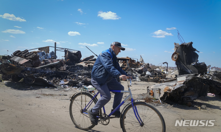 [부차=AP/뉴시스] 지난 10일(현지시간) 우크라이나 키이우 외곽 부차에서 자전거를 탄 주민이 파괴된 러시아군 차량 잔해 주변을 지나가고 있다. 2022.05.20.