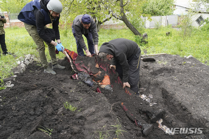 [하르키우=AP/뉴시스] 11일(현지시간) 우크라이나 하르키우 인근 스테파키 마을에서 경찰관이 자원봉사자들과 함께 러시아군의 포격으로 숨진 민간인 시신을 발굴하고 있다. 2022.05.12.