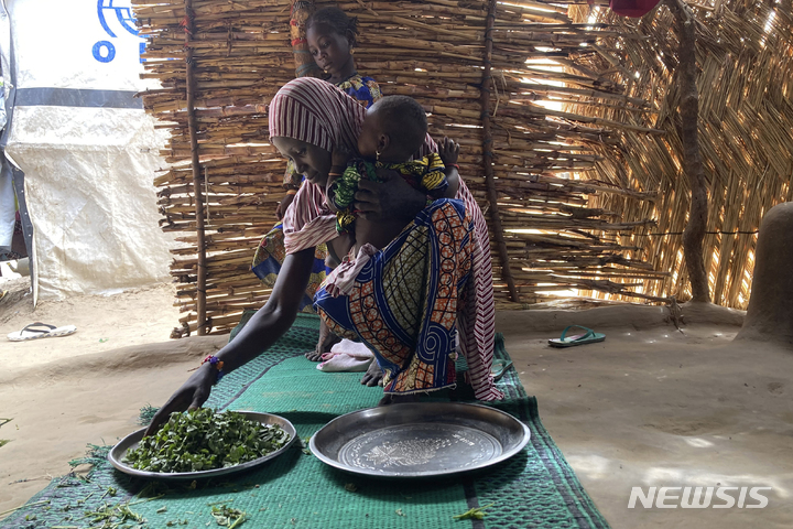 [마이두구리(나이지리아)=AP/뉴시스]나이지리아 동북부 도시 마이두구리에서 한 여성이 식사를 준비하고 있다. 2022.06.16