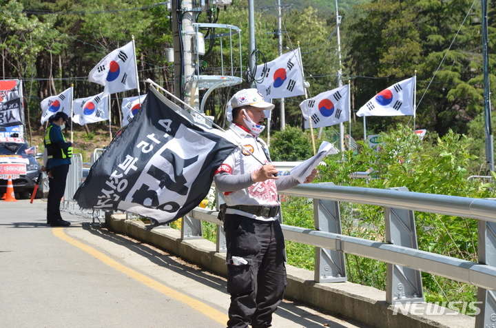 [밀양=뉴시스] 안지율 기자 = 14일 오전 경남 양산시 하북면 평산마을 문재인 전 대통령 사저 앞 도로에서 한 보수단체의 회원이 문 전 대통령 비판 시위를 하고 있다. 이날 평산마을은 몇몇 주민과 관광객만 오갈뿐 대체로 평온한 분위기다. 2022.05.14. alk9935@newsis.com