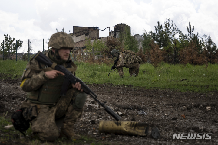 [하르키우=AP/뉴시스] 15일(현지시간) 우크라이나 동부 하르키우 북쪽에서 우크라이나 군인들이 최근 탈환한 마을을 수색하고 있다. 2022.05.16.