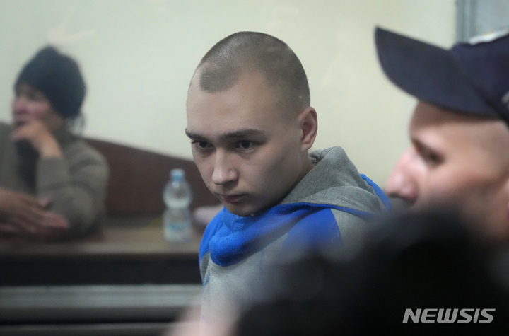 [AP/뉴시스] 18일 우크라 법원의 전쟁범죄 혐의 법정에서 러시아 하사관 피고인이 피고석 유리창 너머로 보이고 있다  