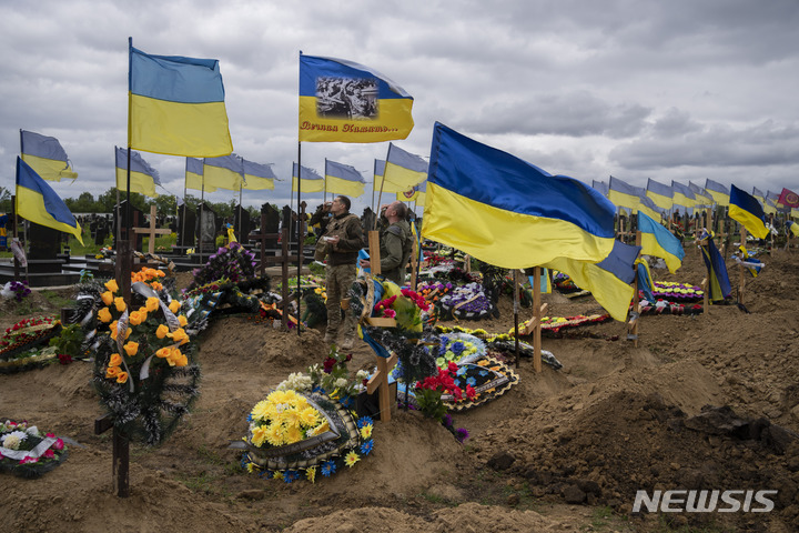 [하르키우=AP/뉴시스] 22일(현지시간) 우크라이나 동부 하르키우 공동묘지에서 우크라이나 군인들이 전우의 묘소를 찾아 참배한 후 술을 마시고 있다. 2022.05.23.
