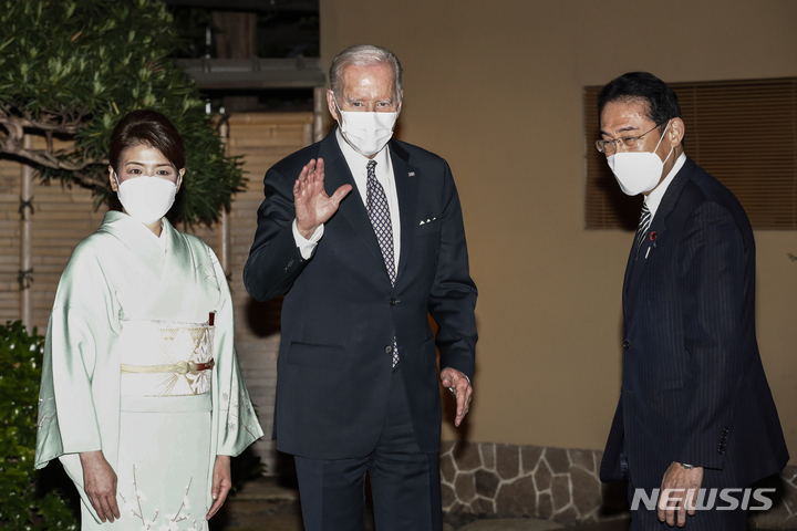 [도쿄=AP/뉴시스]조 바이든 미국 대통령(가운데)이 기시다 후미오 일본 총리(오른쪽) 및 영부인 기시다 유코 여사와 핫포엔 식당에서 만찬에 앞서 손을 흔들어 보이고 있다. 2022.05.23.