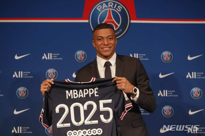 [파리=AP/뉴시스] 파리 생제르맹(PSG)의 킬리앙 음바페가 23일(현지시간) 프랑스 파리의 파리 파르크 데 프랭스에서 열린 기자회견 중 PSG 유니폼을 들고 포즈를 취하고 있다. 음바페는 2025년까지 계약을 연장했다. 2022.05.24.