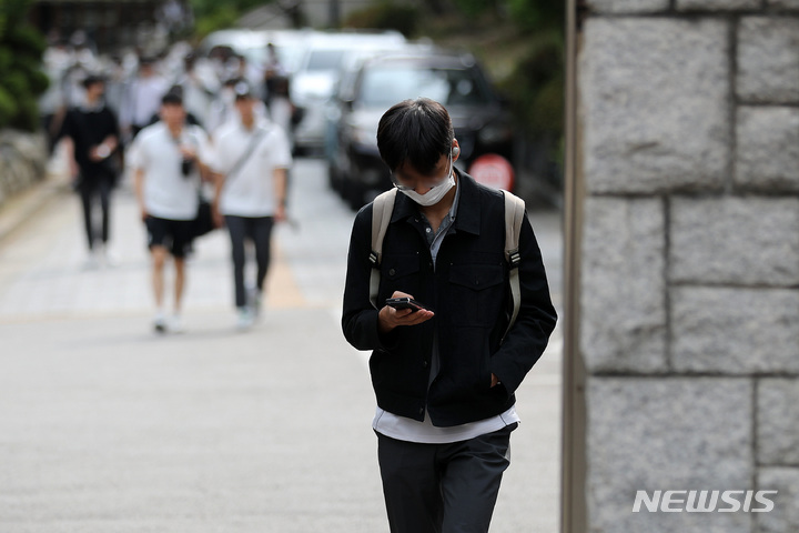 [서울=뉴시스] 백동현 기자 = 지난 5월25일 오후 서울 시내 한 중학교 앞에서 학생들이 스마트폰을 보면서 하교하고 있다. 이날 통계청이 발표한 '2021년 청소년 통계'에 따르면 우리나라 10대 청소년의 인터넷 이용 시간은 주 평균 27.6시간이었다. 이는 2019년 17.6시간에서 크게 증가한 수치다. 2022.05.25. livertrent@newsis.com