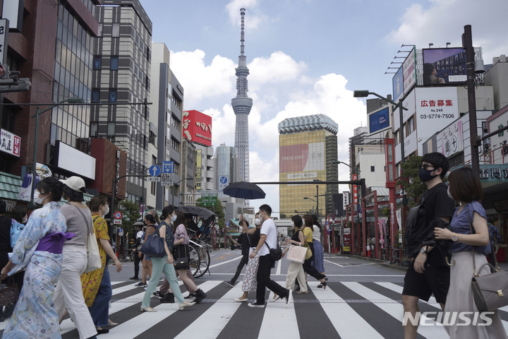 [도쿄=AP/뉴시스] 일본 자료 사진. 사진은 지난해 7월31일 일본 도쿄의 랜드마크인 도쿄 스카이트리 타워 인근 아사쿠사 관광지구의 횡단보도를 따라 사람들이 걸어가는 모습. 2022.08.16.