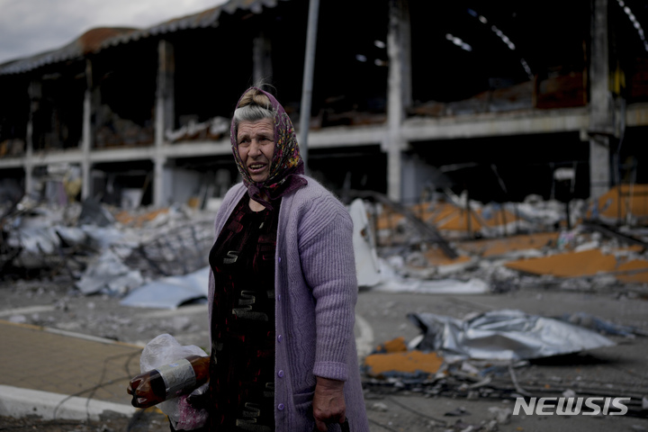 [키이우=AP/뉴시스]26일(현지시간) 우크라이나 키이우 외곽 이르핀에서 한 여성이 공격으로 파괴된 건물 앞에 서 있다. 2022.05.27. photo@newsis.com