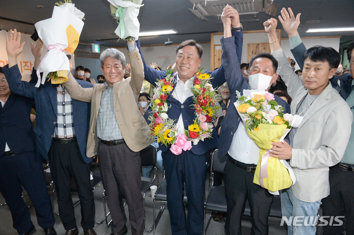 [울산=뉴시스] 배병수 기자 = 제8회 전국동시지방선거에서 진보당 김종훈 동구청장 후보가 자신의 선거사무소에서 당선이 확실시되자 꽃목걸이와 꽃다발을 들고 지지자들과 함께 환하게 웃고 있다. 2022.06.02. bbs@newsis.com